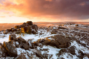 Fiery sunrise over snow covered Belstone Tor, Dartmoor